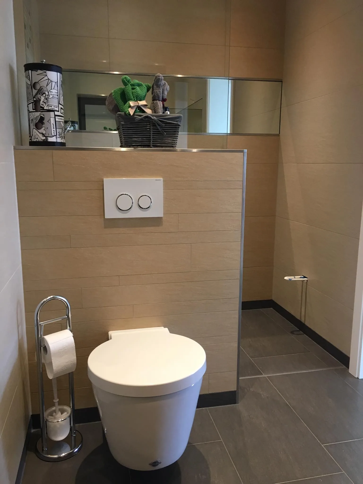 Badgestaltung mit Hänge-WC, beigen Wandfliesen und dunklem Boden